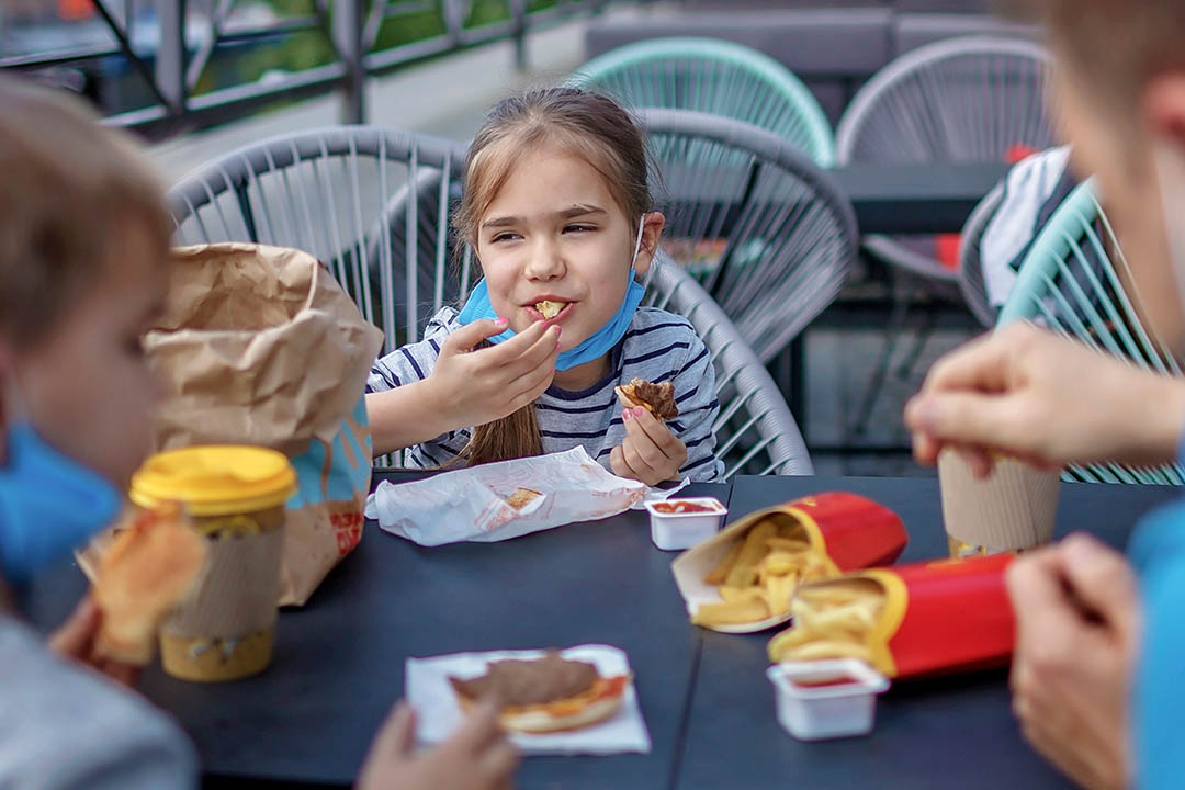 Picture of a young child with friends eating fast food