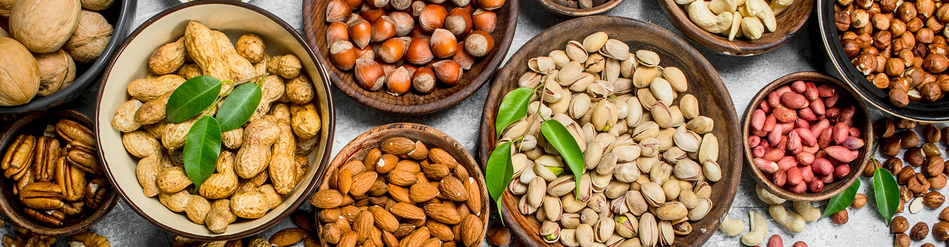 Assortment of different nuts in bowls.